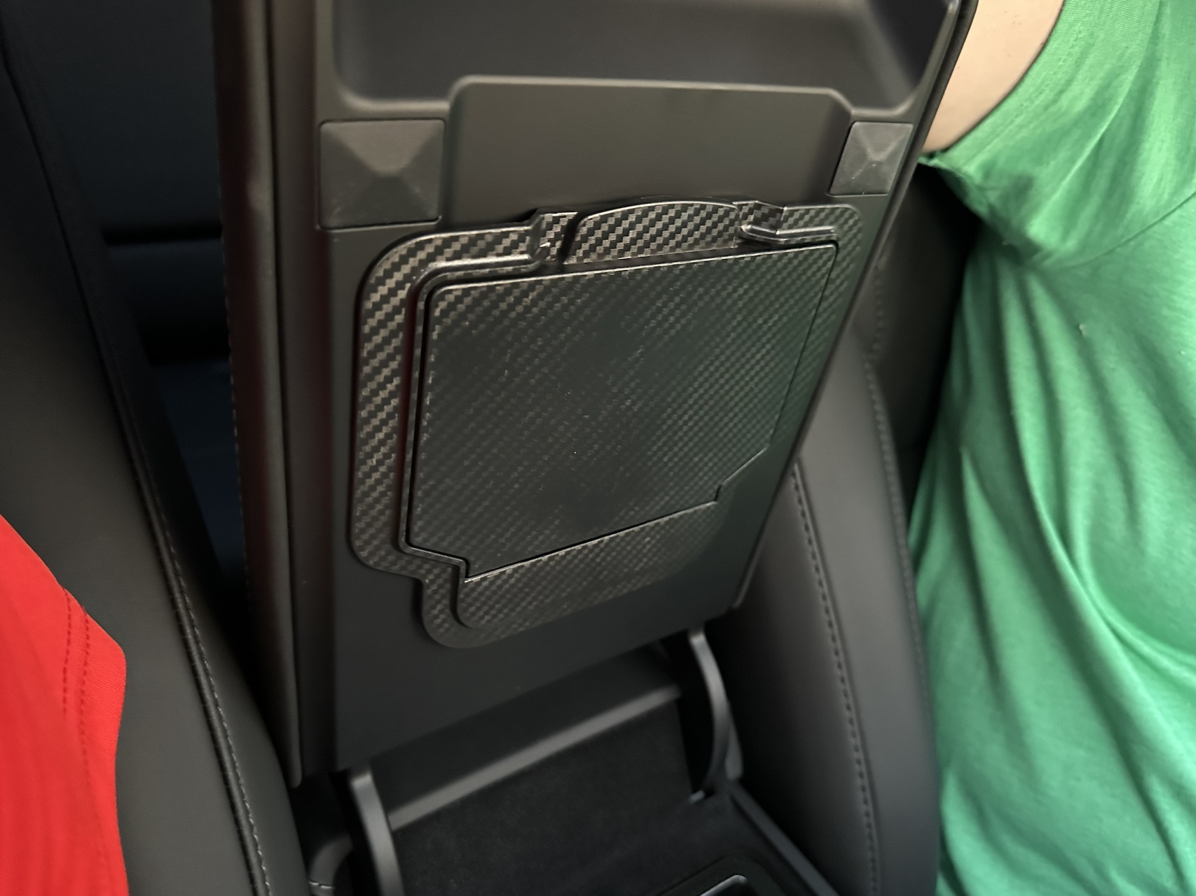 Carbon fiber style rear console storage cover installed in a Tesla Model Y